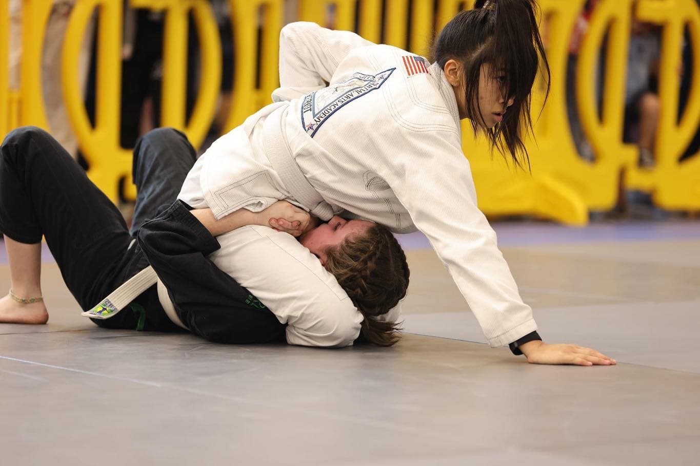 Young student applying a technique during a jiu-jitsu match